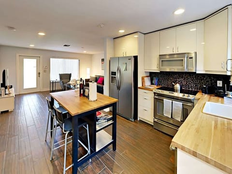 A large wooden kitchen bar seats 2, with plenty of space to share a meal or prep dinner.