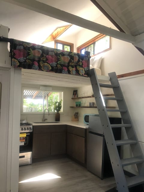 Queen bed in loft with kitchen below.