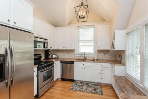The kitchen has beautiful over.head lights and 3 windows-a bright open feel.