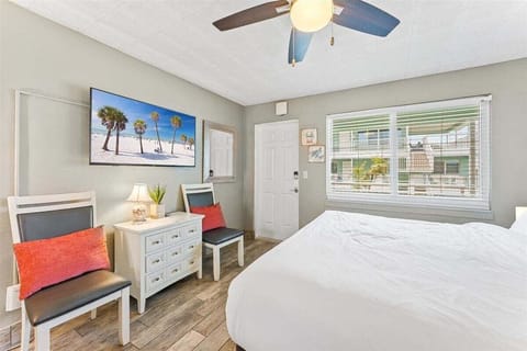 Bright studio suite with a king bed, smart TV, and a fully equipped kitchenette — a cheerful, beachy space where everything you need is right at hand.