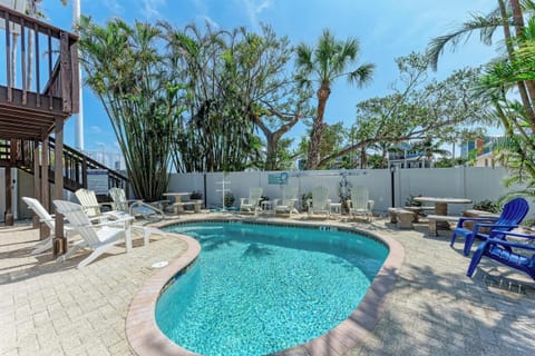 Kidney-shaped heated pool with lounge chairs and lush tropical landscaping