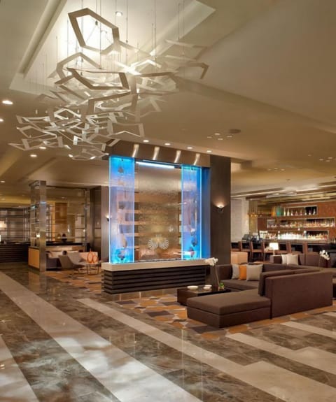 Linger beneath statement lighting in a chic, airy lounge.