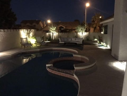Lighted pool area with lounge furniture,  outdoor grill & seating