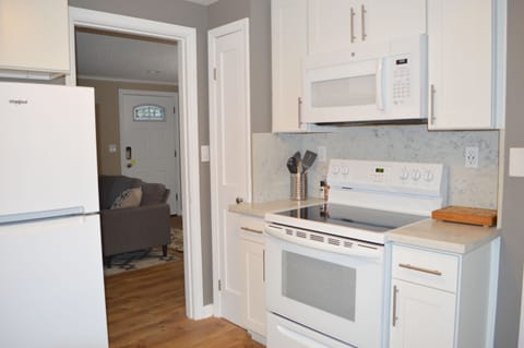Kitchen with fridge, stove, oven, microwave, garbage disposal, utensils & dishes