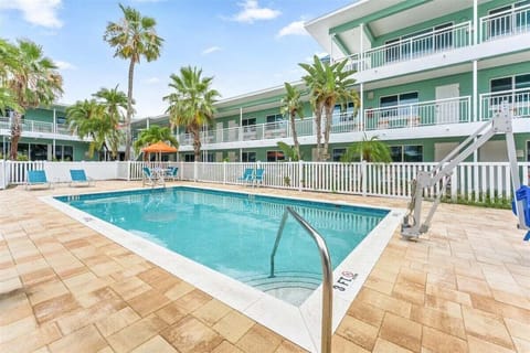Dive into our sparkling saltwater pool with a spacious sun deck, lounge chairs, and handicap access — all surrounded by swaying palms, steps from the beach.