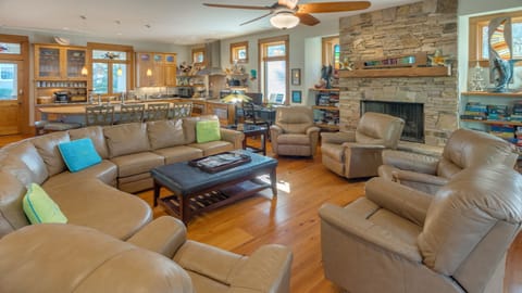 Spacious open-plan living area with leather seating, dining table, and kitchen.