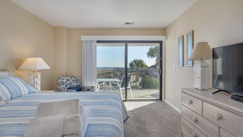 Sliding glass doors lead to a private balcony, creating an inviting spot to enjoy morning light or quiet evenings surrounded by the Lowcountry setting.