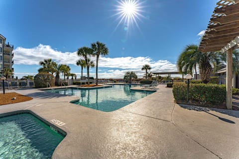 The community pool offers a resort-style setting surrounded by lush trees and open skies—perfect for cooling off after a day at the beach.
