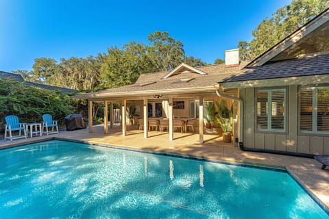 This private backyard retreat features a sparkling pool surrounded by lush landscaping and generous patio space for lounging and outdoor dining.