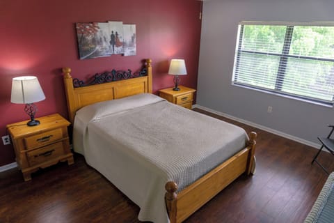 Unwind in a cozy queen bed with warm bedside glow.
