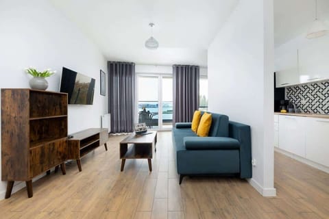 Bright living room with wooden flooring, a sofa, and modern decor.
