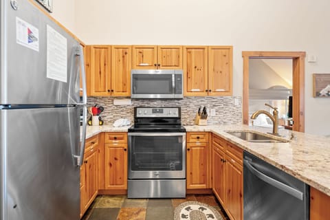Full kitchen featuring stainless steel appliances and breakfast bar.