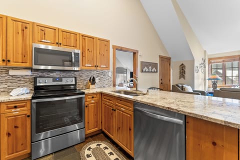 Full kitchen featuring stainless steel appliances and breakfast bar.