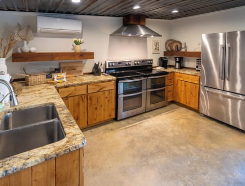Full view of party barn kitchen - dual oven, full size fridge, dishwasher, sink