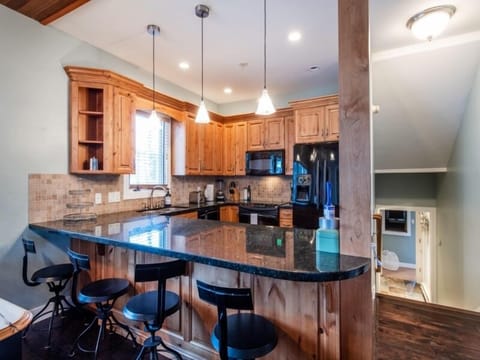 Kitchen with bar seating area.  Master bedroom, bathroom 3 and and entrance way down a few stairs.