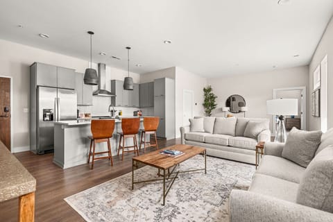 Open-concept living area with abundant natural light, a modern kitchen with island seating, and cozy, stylish furnishings throughout.