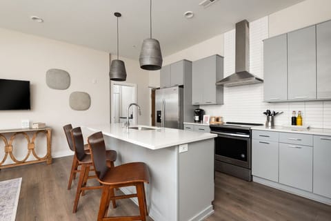 Contemporary kitchen featuring stainless steel appliances, spacious island, and bar seating.