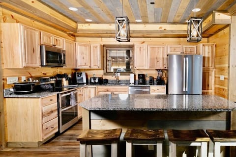 The fully equipped kitchen has stainless appliances, granite countertops and a large island.