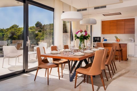 Inside kitchen area and dining table with the floor-to-ceiling glass windows overlooking the private terrace of the luxurious villa Hvar Fantasy for vacation with friends and family