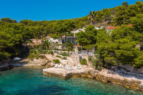 A view of the property of Croatia luxury family villa Anemos with an outdoor terrace and sunbathing area on the beach on the island of Hvar
