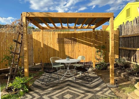 Private outdoor area w/ custom cedar pergola, dining table and solar lights