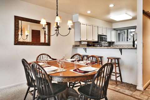 The dining room includes a wooden oval table and chairs with seating for 6