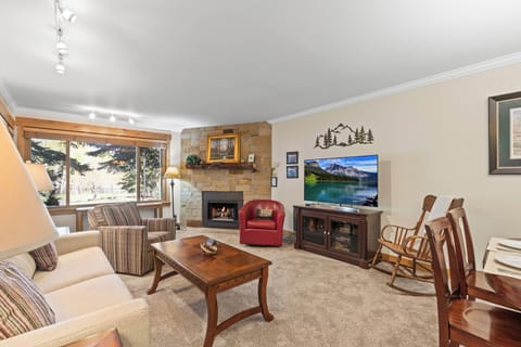 The living room with comfortable furnishings, cozy fireplace and flat screen TV.