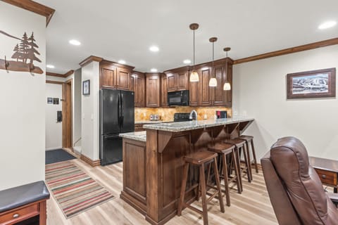 Your fully-equipped kitchen beckons with rich wood cabinetry, granite counters, and a breakfast bar with seating for 4 guests.