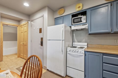 Snow Flower 72's kitchen with blue cabinets and white appliances.