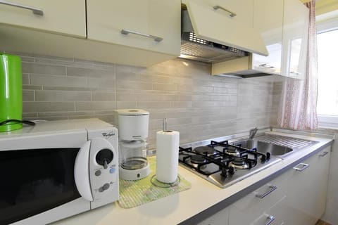 The kitchen equipped with coffee maker, kettle, microwave, stove
