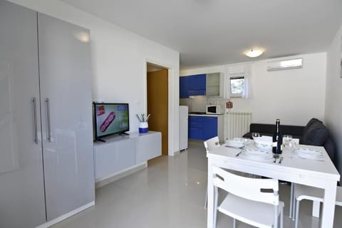 The dining area with a table and 4 chairs, wardrobe, flat-screen satellite TV.