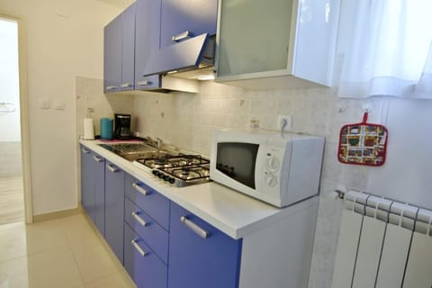 The kitchen is equipped with a stove, extractor hood, kettle, coffee machine.