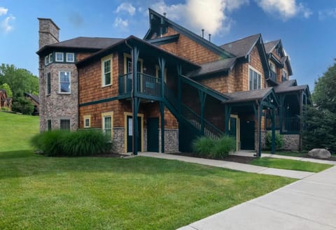Charming Adirondack exterior with spacious green lawn for outdoor fun
