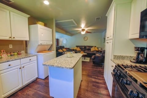 Full pantry and cabinets with kitchen center island complete this full functional kitchen with stackable washer dryer for use.