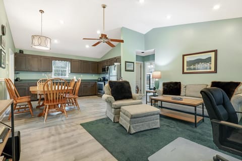 Living Area - The spacious living area features a sofa sleeper, side chair with ottoman, small desk with chair, and a large, mounted television. The relaxing, coastal colors will welcome you upon entry.