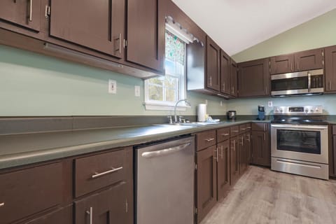 Kitchen - The ample kitchen features stainless appliances which include a dishwasher, oven, cooktop, microwave, and refrigerator with ice maker.