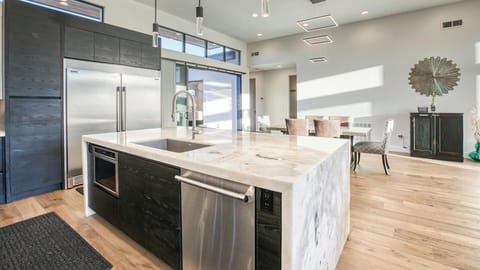 Kitchen with pro appliances, marble accents & under-cabinet lighting.