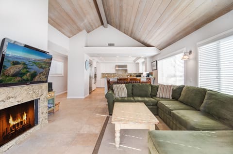 Living room facing the dining area and kitchen. Tv has been upgraded to 80 inch.