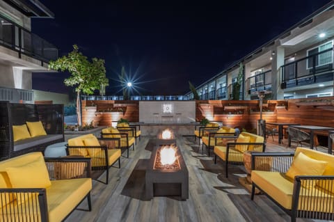 Gather by glowing fire pits in a stylish outdoor courtyard.