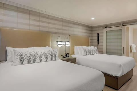 Stretch out on crisp linens under warm, ambient bedside lighting.