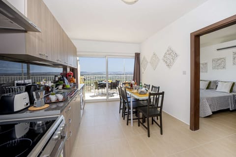 fully equipped kitchen and dining area overlooking the sunny terrace with views