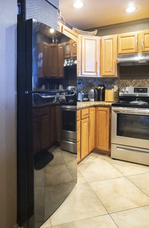 A brand new full sized refrigerator in the fully equipped kitchen.
