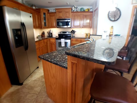 Well stocked kitchen with plenty of plates, cups, utensils and cookware