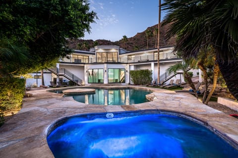 Capture the epitome of luxury living with the spa and pool glistening in the foreground, while the elegant 2-story home stands in the background.