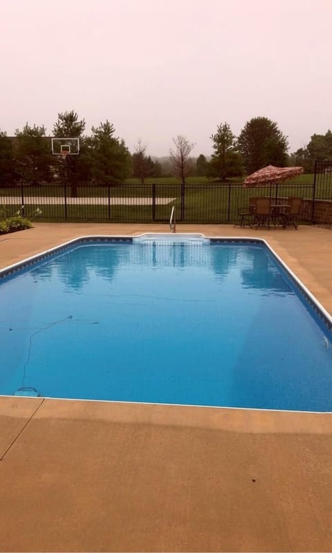 Looking from pool house across the pool at the 3-point line basketball court