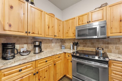 Full kitchen with stainless steel appliances and breakfast bar seating.