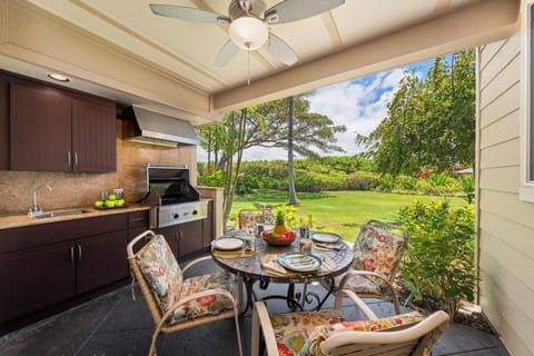 Covered lanai with seating for four and BBQ