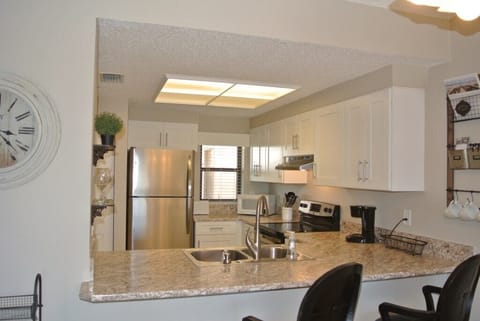 Modern kitchen with stainless steel appliances and granite countertops.