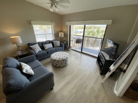 Modern living room with plush sofas and access to a scenic balcony.