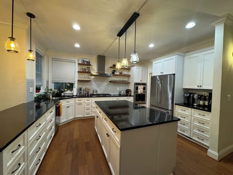 Fully stocked kitchen with cooking and baking utensils, spices, coffee makers